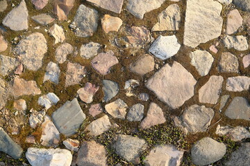 Top view of stone road fragment. Dry land with stones. Abstract natural textured background.
