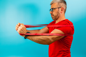 Man exercises with resistance bands at home studio