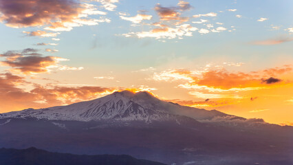Obraz premium beautiful mountain sunset or sunrise with majestic mountaoin with white snow peak and beautiful cloudy sky on background