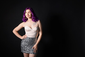 Fototapeta premium Beautiful woman with bright purple hair and tattoo in Latin on black background. Space for text