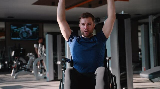 Wheelchair user doing shoulder press at gym