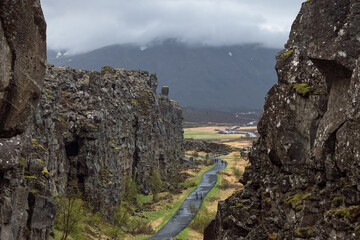 Dramatic rift valley landscape at Thingvellir National Park, Iceland, with a winding path between...