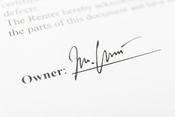Owner's handwritten signature on paperwork, closeup view