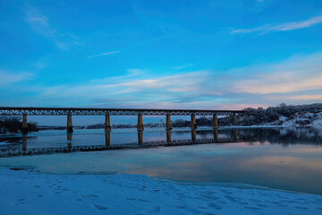 Obraz premium Bridge over the river at sunset