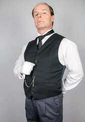 Butler or Hotel Concierge in Formal Waistcoat and White Gloves Standing at Elegant Attention. At Your Service.