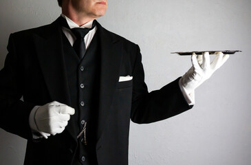 Butler or Formal Waiter in Black Morning Coat and White Gloves Holding Serving Tray. Professional Hospitality and Courtesy.
