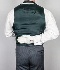 Butler or Hotel Concierge in Formal Waistcoat and White Gloves Standing at Elegant Attention. At Your Service.