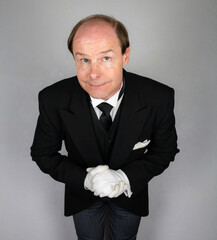 Butler or Hotel Concierge in Black Morning Coat and White Gloves Eager to Be of Service. Professional Hospitality and Courtesy.