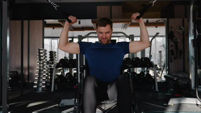 Man in wheelchair doing resistance training in gym