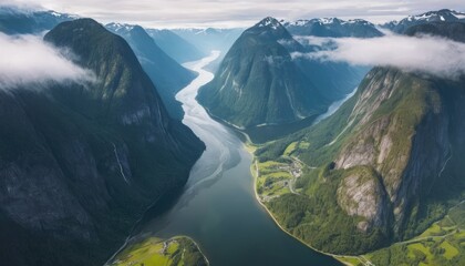 From an aerial view, the panoramic landscape shows a mountain river reflecting the sky near high rocky peaks with some mountain forests.