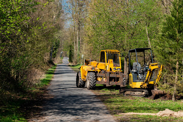 Heavy machinery working on a rural road in springtime