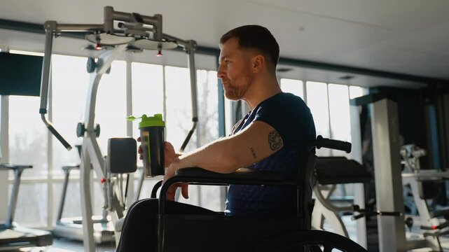Wheelchair user athlete drinking protein shake after training