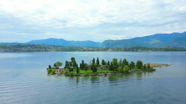 Aerial view of Isola Dei Conigli in Manerba with the cliff overlooking Lake Garda with crystal clear water. We are in the province of Brescia, Lombardy, Italy. The video expresses serenity and peace
