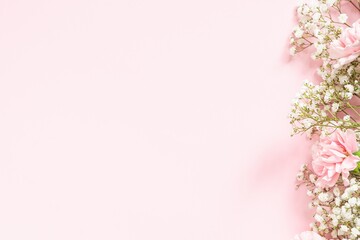 Bouquet of white gypsophila and pink carnations on a pink background in the corner, copyspace