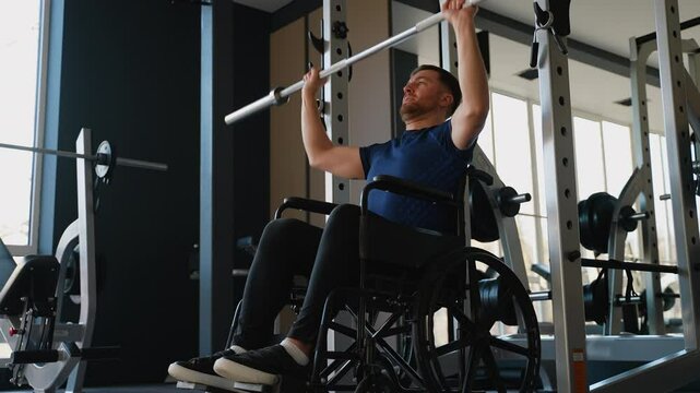 Man in wheelchair lifting barbell in gym