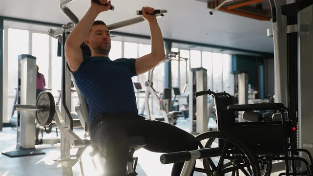 Man with disability training back muscles on lat pulldown machine