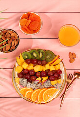 Fruit salad with kiwi, mango, dragon fruit, grapes, nuts, citrus fruits with chia seeds for weight...