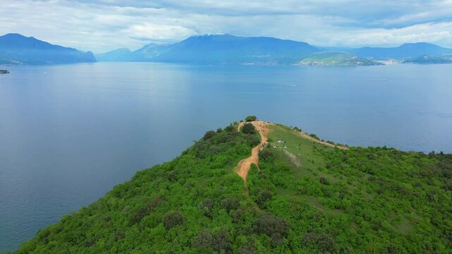 Aerial view of Rocca di Manerba with the cliff overlooking Lake Garda in the province of Brescia, Lombardy, Italy. The video expresses serenity and peace while waiting for the summer season 