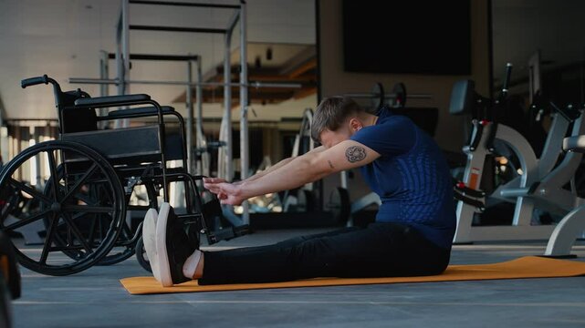 Man with disability stretching on yoga mat in gym
