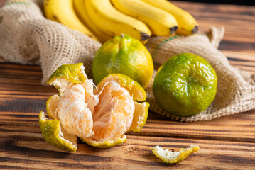 Oranges and Bananas, oranges and bananas positioned on a rustic wooden surface and dark background, selective focus.