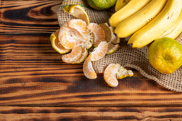 Oranges and Bananas, oranges and bananas positioned on a rustic wooden surface and dark background, selective focus.