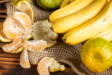 Oranges and Bananas, oranges and bananas positioned on a rustic wooden surface and dark background, selective focus.