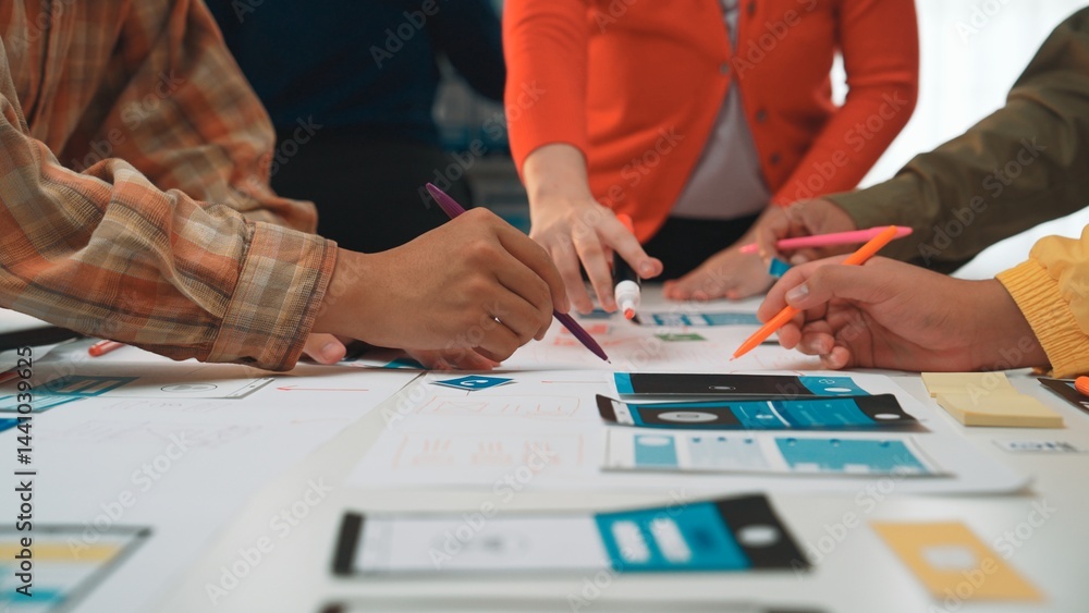Poster engaged team members actively discuss and create user interface prototypes during a collaborative wo