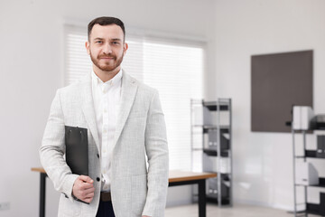 Fototapeta premium Happy recruiter with clipboard in office, space for text