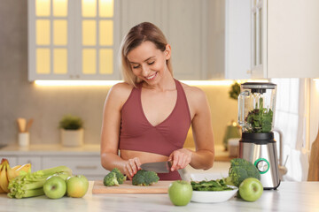 Weight loss. Happy woman cutting broccoli for healthy shake at table in kitchen