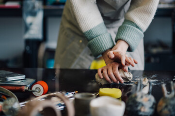 Ceramist kneading clay for pottery creation in workshop