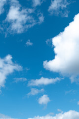 White clouds in the blue sky on a bright sunny day.