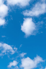 White clouds in the blue sky on a bright sunny day.
