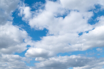 White clouds in the blue sky on a bright sunny day.