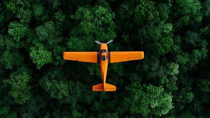 top view orange airplane flying over a deep green forest
