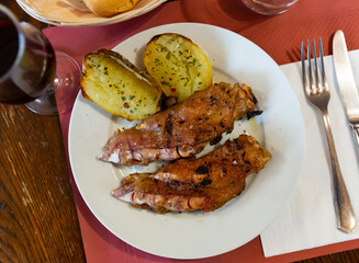 Pig's trotter with potato cooked and served on table in restaurant.
