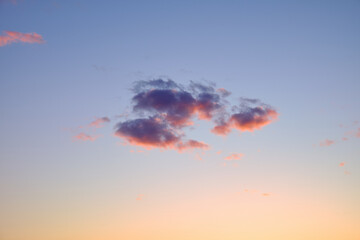 Beautiful sunset sky with soft colorful clouds in pastel tones. Calm evening atmosphere with pink and purple hues.