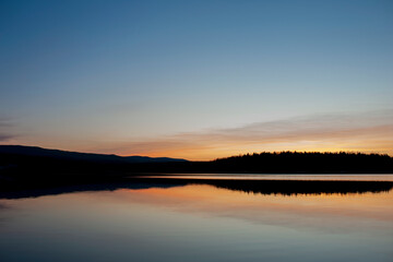Panorama of dawn fire in the sky above the natural pasture. Golden red clouds just before sunrise. Picturesque landscape at sunrise. Beauty in nature