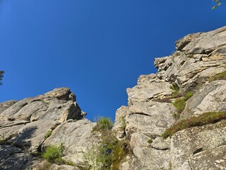 Tustan Rocks in Spring, Carpathian Mountains, Ukraine. Scenic view of Tustan rock formations surrounded by spring forest under a blue sky. Historical and natural landmark in the Carpathian Mountains