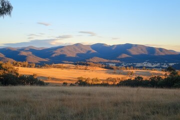 Obraz premium Golden Sunrise Over Highland Grasslands and Distant Mountains in Rural Britain 