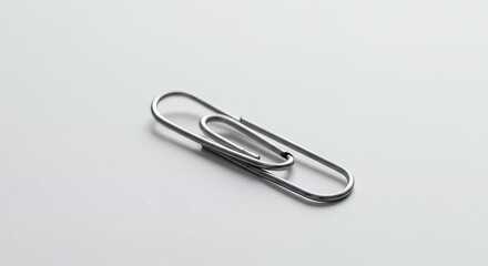 Isolated Silver Paperclip on White Background Symbolizing Fragility and Connection in Minimalist Style and Office Supply Concept