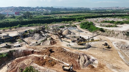 Equipamentos industriais pesados em operação em uma planta de extração de minérios, com correias transportadoras, trituradores e esteiras rolantes.