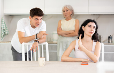Elderly woman mother and young guy during family quarrel accuse adult daughter, prove her wrong