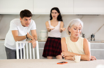 Adult children guy and girl are fighting with elderly woman mother. Family feuds, generational...