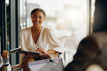 A joyful and enthusiastic woman actively engages with her colleagues in a bright, contemporary...