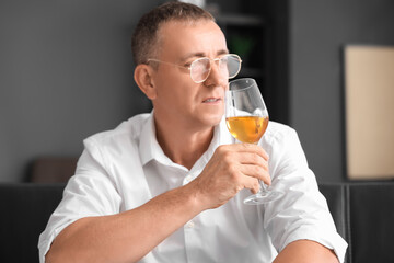 Fototapeta premium Mature man tasting wine at home, closeup