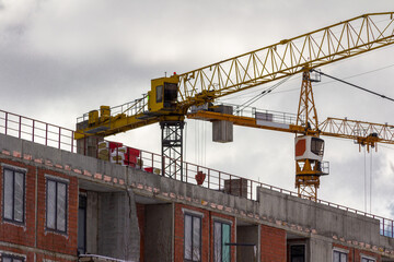 Construction site with tower crane. House and buildings construction. Hotel apartments construction. Housing renovation, real estate. Crane on formwork in Built environment.