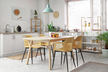 Interior of stylish kitchen with dining table, chairs and lamp