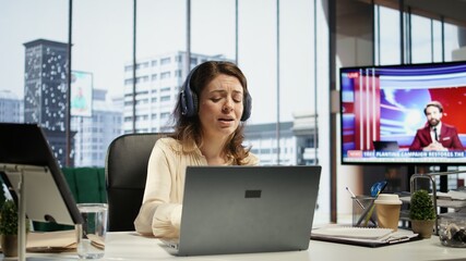 Female entrepreneur enjoys multitasking with her favorite music on headset, singing and dancing at...