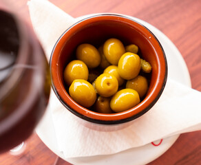 Delicious pickled green olives with cucumber served on plate, spanish dish - Olivas verdes y pepinos