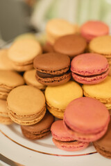 Assorted colorful macarons stacked on a dessert plate at a wedding